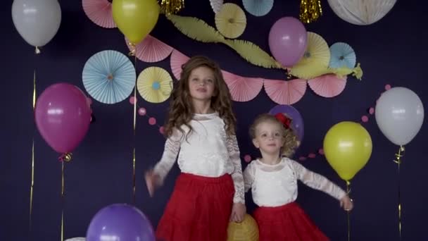 Dos hermanas bebés saludando y celebrando en fiesta de cumpleaños
 - Metraje, vídeo
