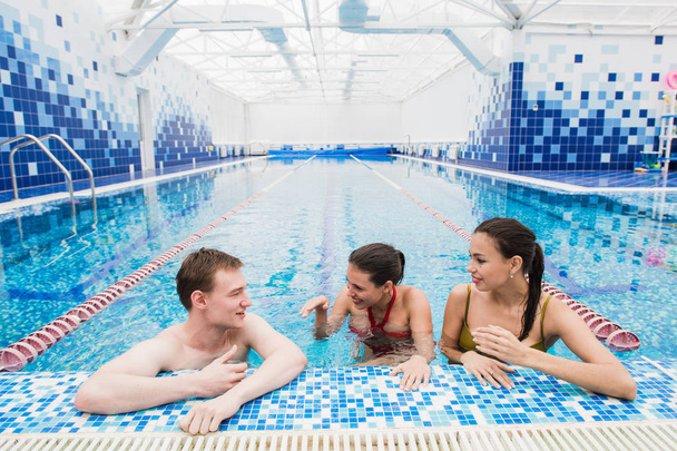 Молодые люди веселятся, разговаривая в бассейне
 - Фото, изображение