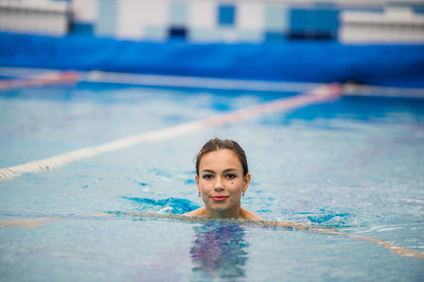 Smiling portrait of beautiful woman in swimming pool - Zdjęcie, obraz
