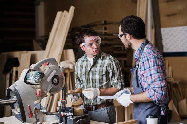 Two men builder with circular saw having a conversation - Photo, Image