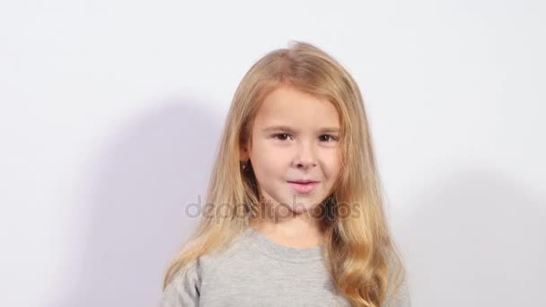 Girl sends an air kiss. Portrait of a caucasian child with positive emotions. Charming girl blowing a kiss - Footage, Video