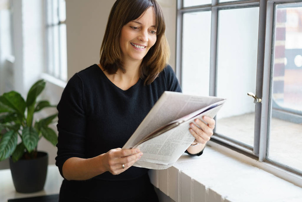 Relaxed woman reading newspaper - Photo, Image