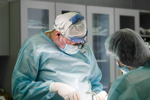 Équipe chirurgicale effectuant une chirurgie esthétique en opératine hospitalière
 - Photo, image