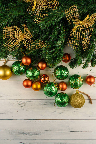 holiday New Years decorations. Christmas tree with many green and red balls near and golden bows on it - Photo, Image