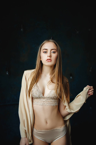 Young sexy woman in a beautiful handmade cream lingerie. - 写真・画像