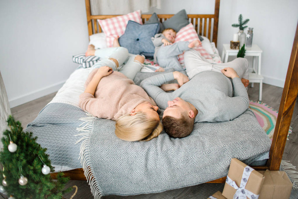 Happy young parents with baby boy in christams decorated room - Foto, Bild