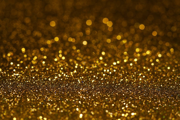  Abstract dark golden glitter background with shining light and soft bokeh, festive colors - Photo, Image