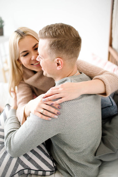 Young beautiful happy smilling blond couple in living room - Foto, afbeelding