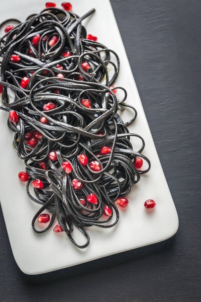 Black pasta with pomegranate seeds - Photo, Image