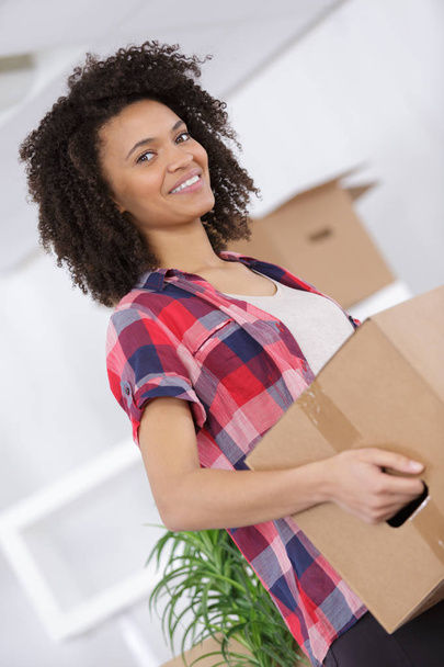 happy woman moving in carrying cartons boxes - Foto, Imagem