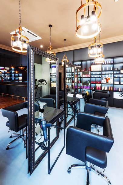 modern designer interior of a beauty salon with mirrors, lamps, armchairs, cosmetics - Foto, Imagem