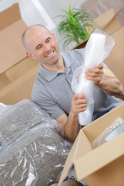 picture of smiling man carrying carton boxes - Fotó, kép