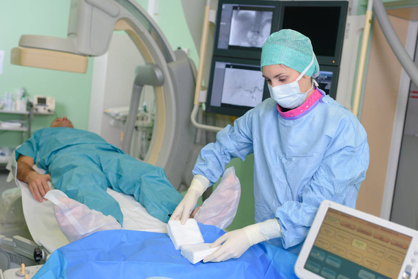 patient lying on mri machine while doctor operating it - Φωτογραφία, εικόνα