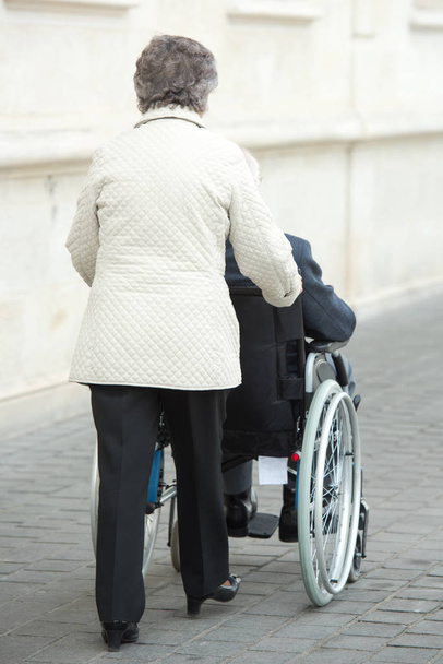 couple in wheelchair outdoors - Foto, imagen