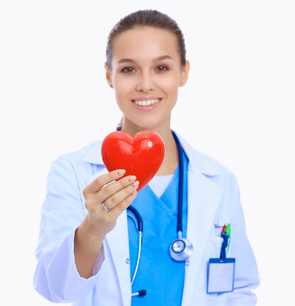 Positive female doctor standing with stethoscope and red heart symbol isolated - Fotó, kép