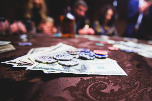 Un primo piano immagine vibrante di tavolo da casinò multicolore con roulette in movimento, con la mano di croupier, e un gruppo di ricchi ricchi giocatori d'azzardo sullo sfondo
 - Foto, immagini