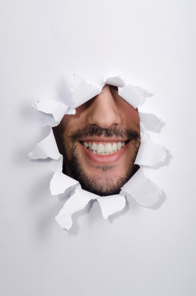 Άντρας πρόσωπο μέσα από την τρύπα στο χαρτί - Φωτογραφία, εικόνα
