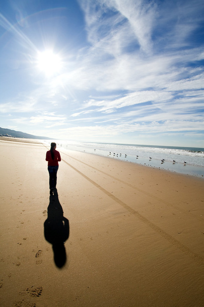 Женщина силуэт прогулки в одиночку на пляже
 - Фото, изображение