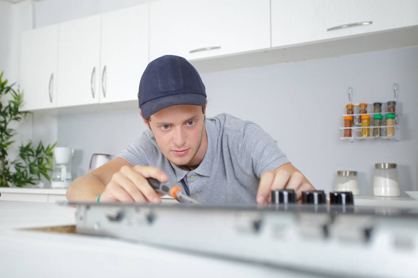 Young man fitting kitchen hob - Photo, Image