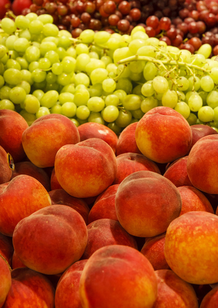 Melocotones y uvas en el mercado
 - Foto, Imagen