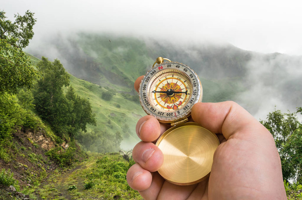Путешественник с компасом ищет прямой путь сквозь туман
 - Фото, изображение