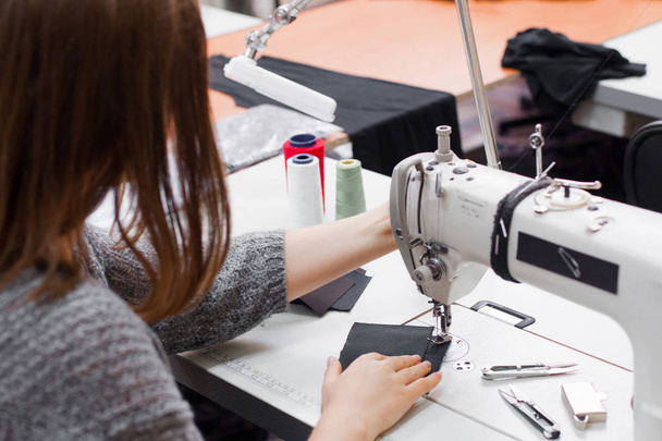 Seamstress sewing at machine, back view - Foto, Imagem