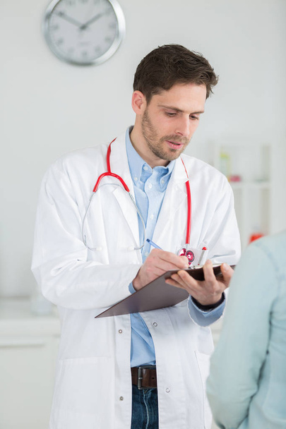 doctor taking notes to diagnose patient - Foto, afbeelding