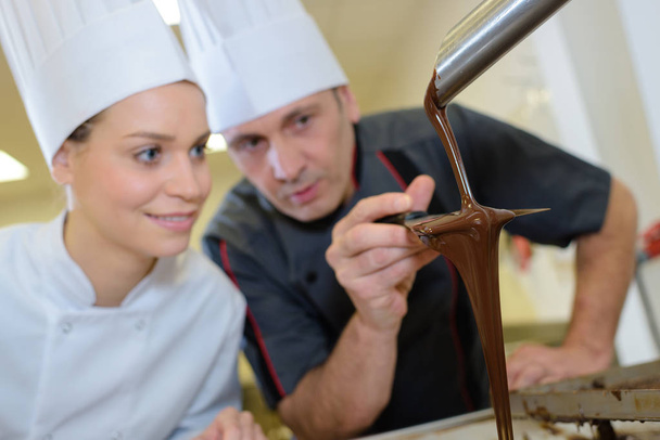 team of pastry cooks smiling a commercial kitchen - Fotoğraf, Görsel