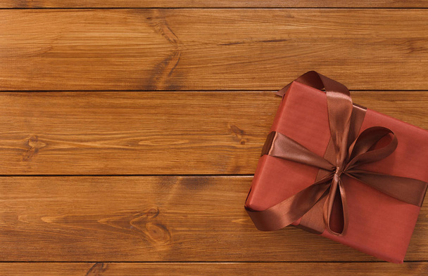Подарочная коробка на деревянном фоне с местом для копирования
 - Фото, изображение