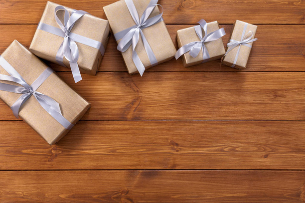 Подарки в подарочных коробках на деревянном фоне
 - Фото, изображение