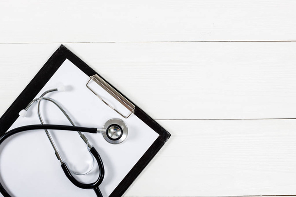 Medyczne schowka i stetoskop na biały drewniany stół - Zdjęcie, obraz