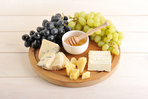 cheese plate - various types of cheese, grapes green and black,  - 写真・画像