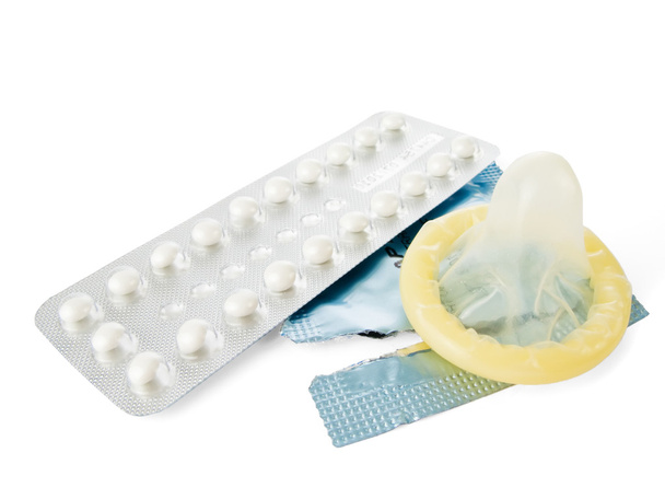 противозачаточные таблетки и презерватив, изолированные на белом
 - Фото, изображение