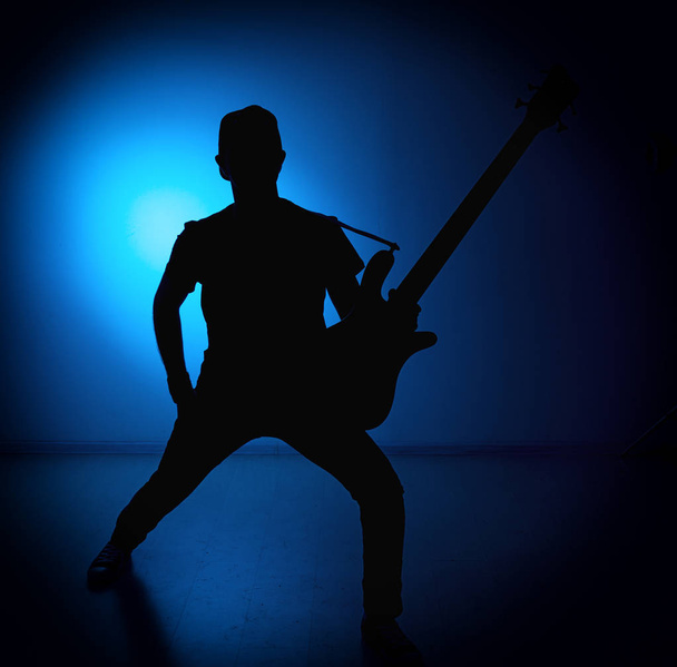 silhouette guitarists of a rock band with guitar on blue background - Foto, immagini
