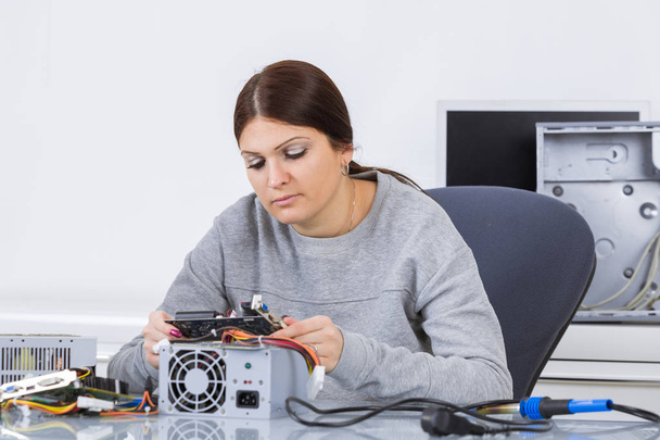 Woman examining computer component - Fotoğraf, Görsel