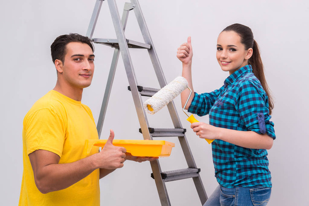 Jovem casal parede de pintura em casa
 - Foto, Imagem
