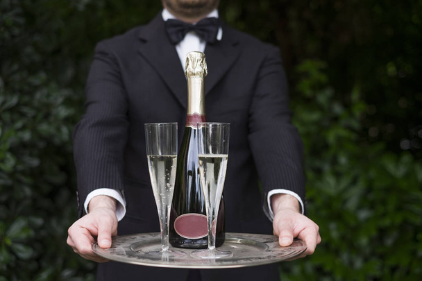 Kellner in Uniform serviert Champagner - Foto, Bild