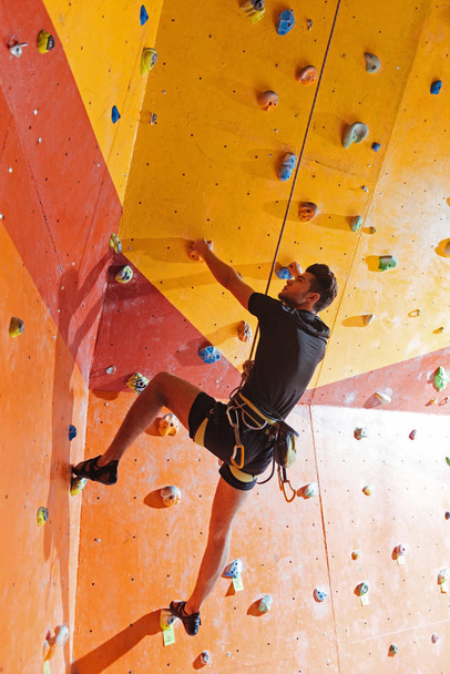 Athletic man training hard in climbing gym - Zdjęcie, obraz