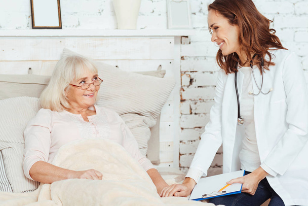 Professional kind doctor visiting elderly woman - Фото, изображение