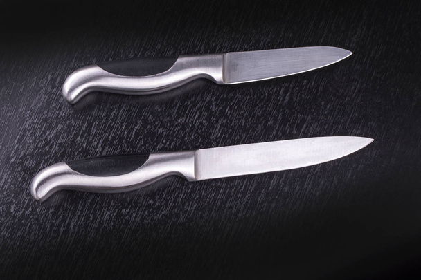 два кухонных ножа на черном столе
 - Фото, изображение