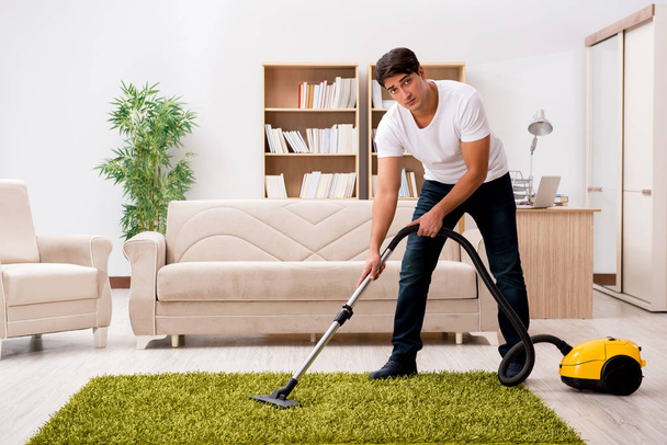 Man cleaning home with vacuum cleaner - Photo, Image