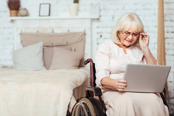 Nice disabled aged woman using laptop - 写真・画像