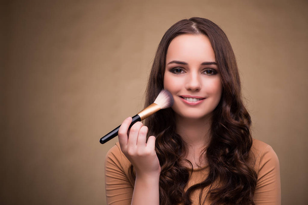 Belle femme appliquant maquillage dans le concept de beauté - Photo, image