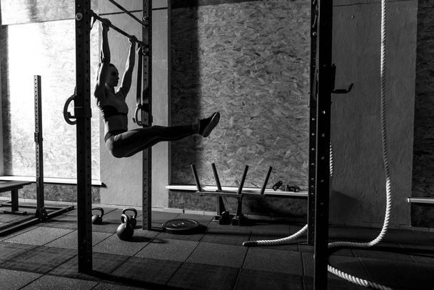 Nice slender woman exercising on the horizontal bar - Фото, зображення