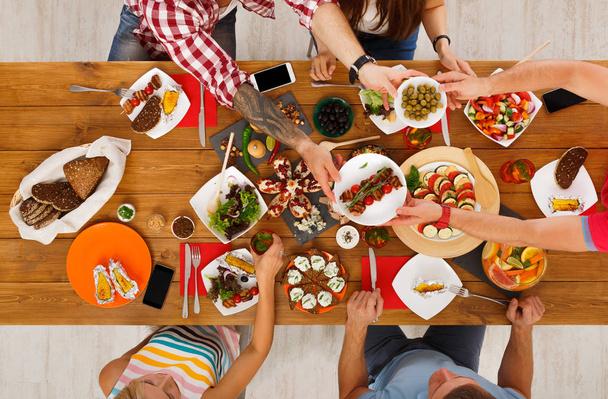 Mensen eten gezonde maaltijden op feestelijke tabel diner - Foto, afbeelding