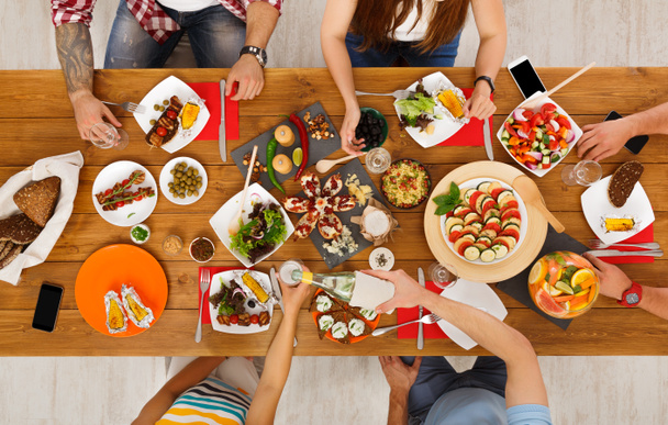 Lidé jíst zdravá jídla na sváteční stůl večerní párty - Fotografie, Obrázek