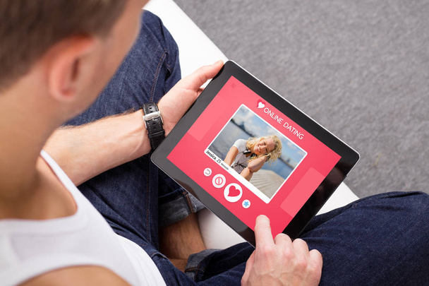 Ο άνθρωπος χρησιμοποιώντας την online εφαρμογή γνωριμιών στο tablet - Φωτογραφία, εικόνα