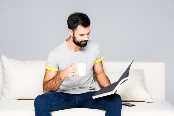 Бородатий чоловік читає журнал
 - Фото, зображення