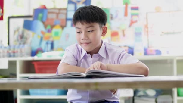 asiatisches Kind in Studentenuniform liest und schreibt für die Hausaufgaben der Schule . - Filmmaterial, Video