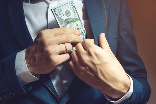 man businessman taking notes in pocket as a bribe - Foto, Imagen